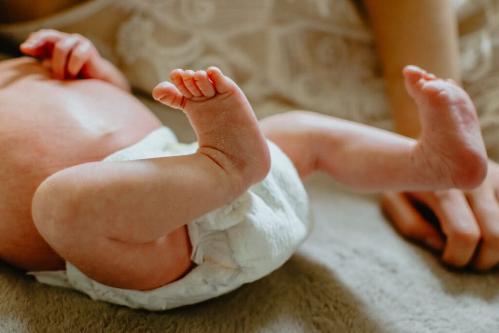 You can see baby torso and down. Focus is on babies feet which are curled up.